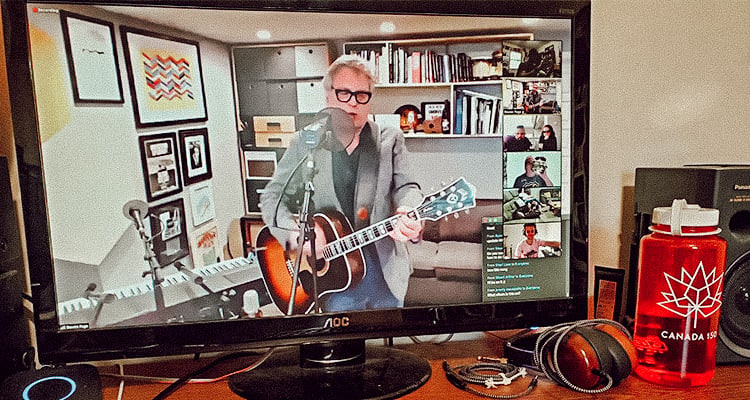 A virtual concert in progress on a computer screen in a home office